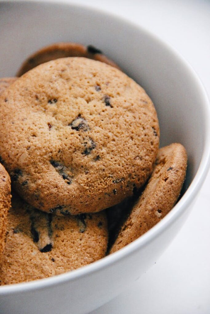 pexels-photo-3250406 A close-up of freshly baked chocolate chip cookies in a white bowl, perfect for food blogs.